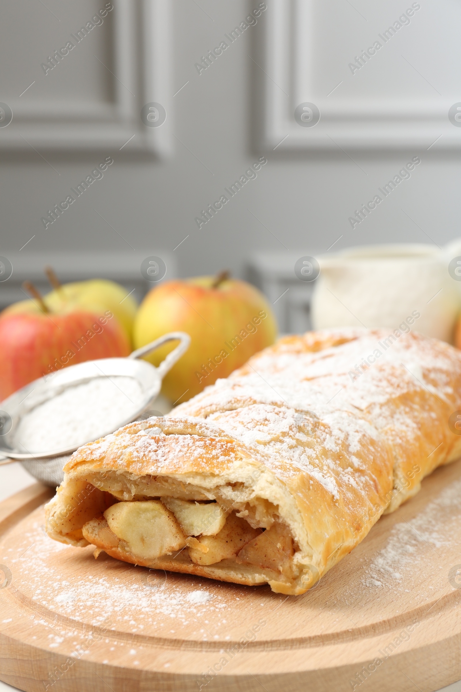 Photo of Delicious strudel with apples and powdered sugar on table, closeup