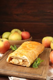 Delicious strudel with apples and mint on table, closeup