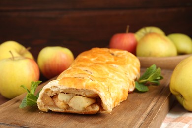 Delicious strudel with apples and mint on table, closeup