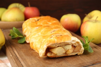 Delicious strudel with apples and mint on table, closeup