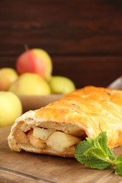 Delicious strudel with apples and mint on table, closeup