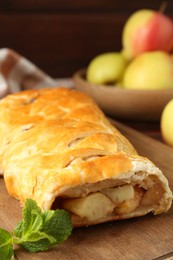 Delicious strudel with apples and mint on table, closeup