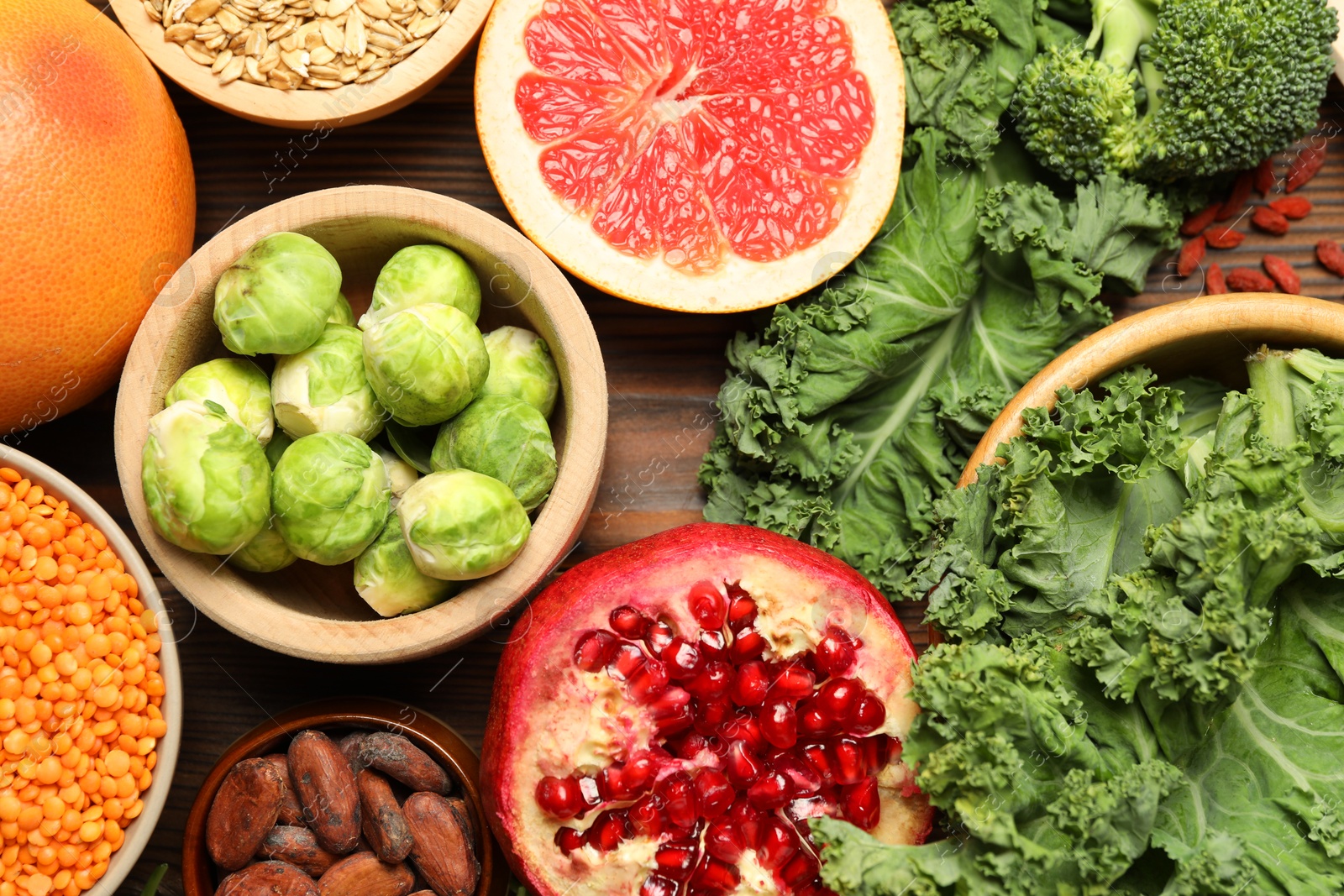 Photo of Different superfood products on wooden table, flat lay