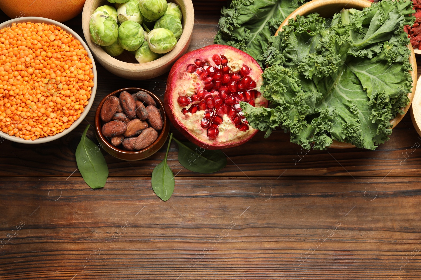 Photo of Different superfood products on wooden table, flat lay. Space for text