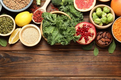 Photo of Different superfood products on wooden table, flat lay. Space for text