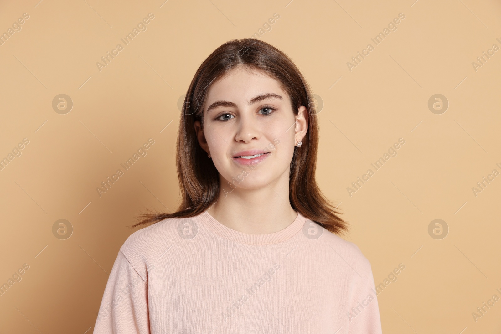 Photo of Portrait of beautiful teenage girl on beige background