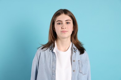 Photo of Portrait of beautiful teenage girl on light blue background