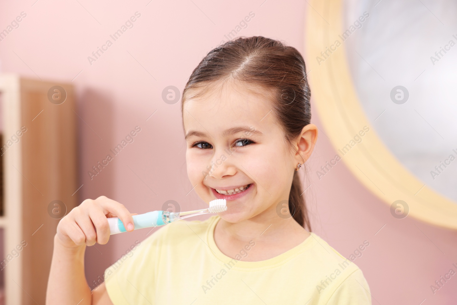 Photo of Cute girl brushing her teeth in bathroom