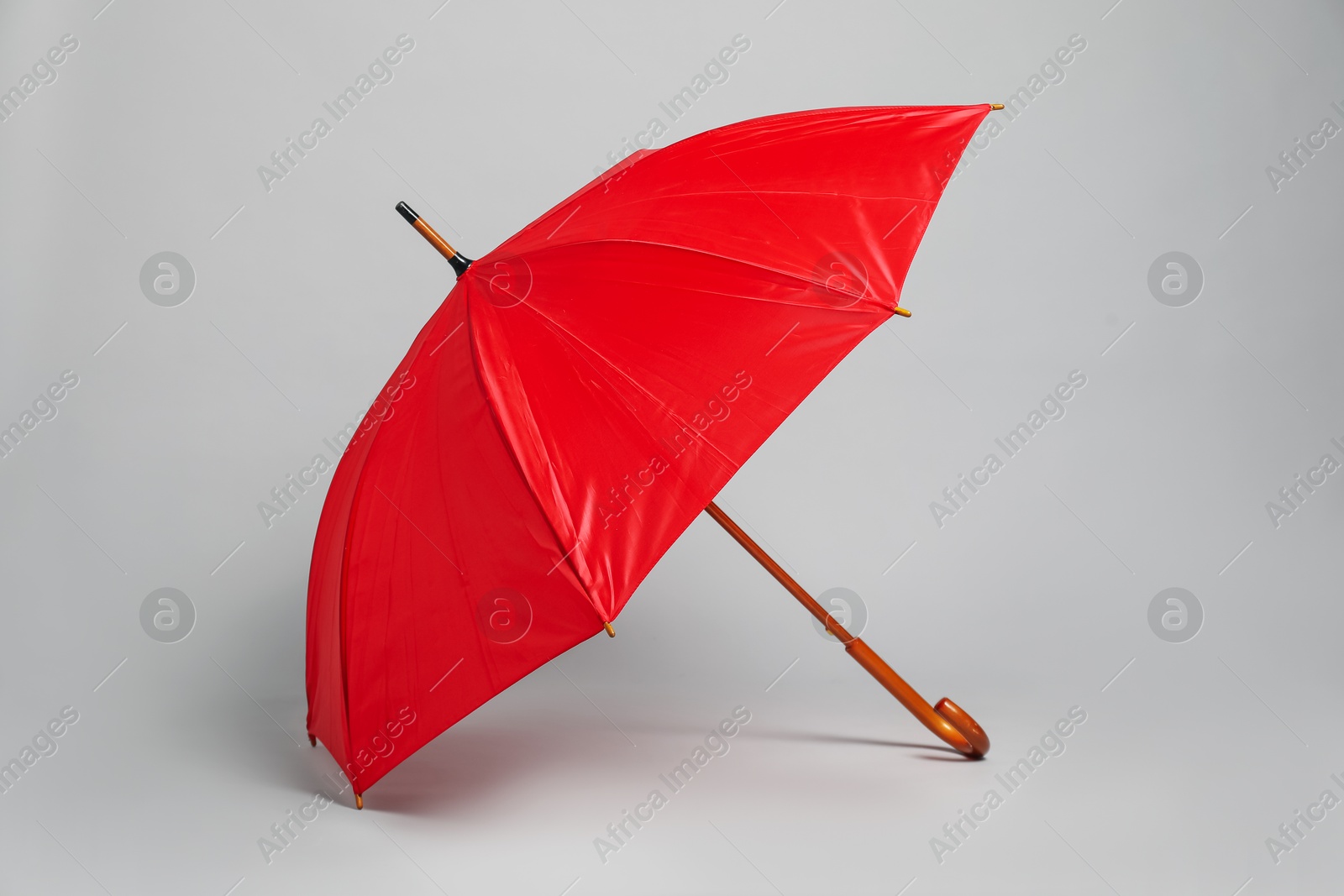 Photo of Open blank red parasol for branding on light grey background. Mockup for design