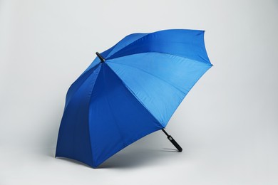 Photo of Open blank blue parasol for branding on light grey background. Mockup for design