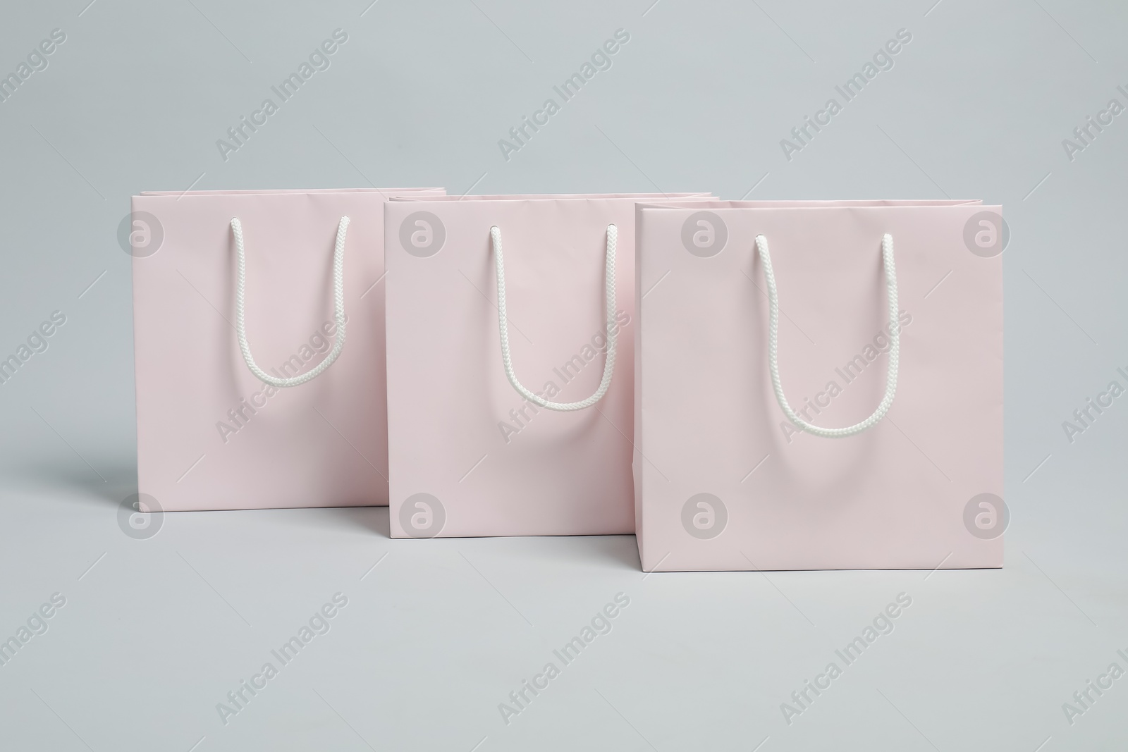 Photo of Blank shopping bags on light grey background. Mockup for design