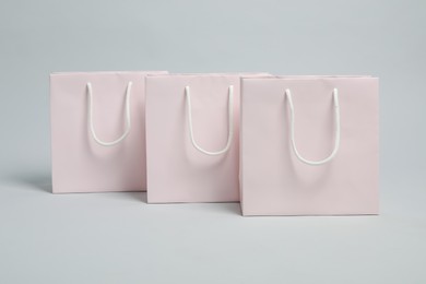 Photo of Blank shopping bags on light grey background. Mockup for design