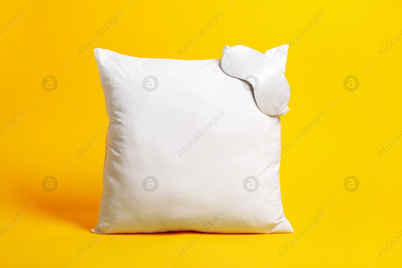 Photo of Blank pillow and sleeping mask for branding on orange background. Mockup for design