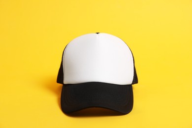 Photo of Blank baseball cap for branding on orange background. Mockup for design