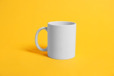 Photo of Blank white mug for branding on orange background. Mockup for design