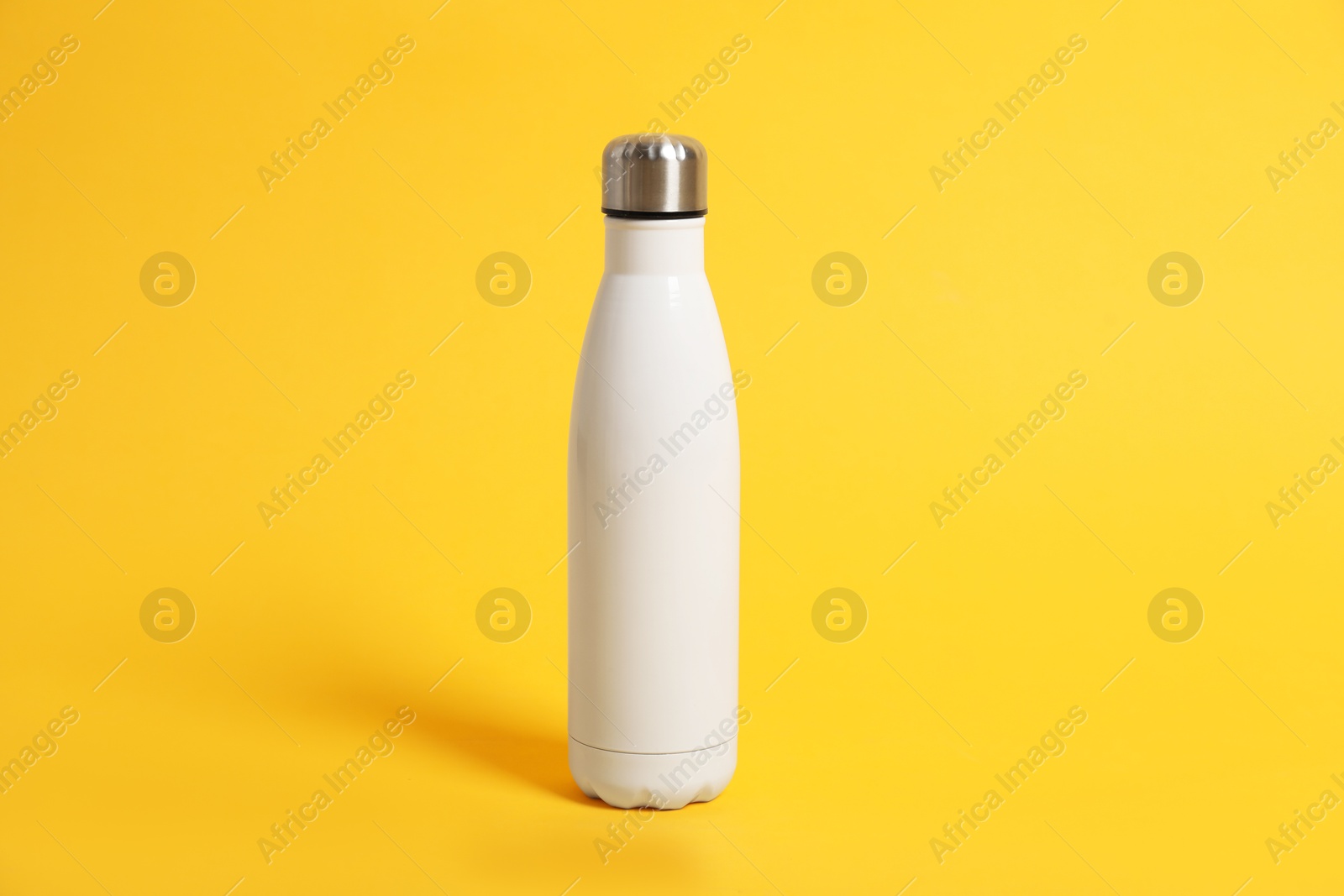 Photo of Blank thermo bottle for branding on orange background. Mockup for design