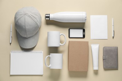 Photo of Different blank items for branding on beige background, flat lay. Mockup for design