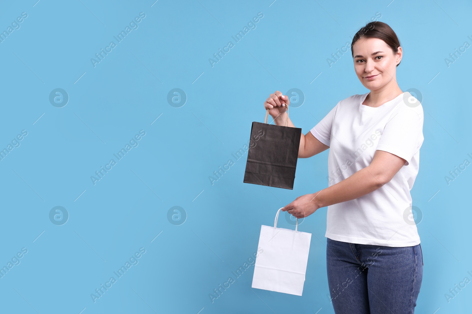 Photo of Woman with blank items for branding on light blue background. Mockup for design