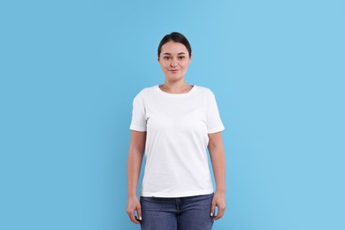 Photo of Woman in white t-shirt on light blue background. Mockup for design