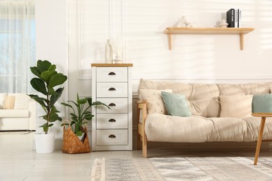 Photo of Beautiful sofa with cushions and coffee table in living room. Interior design