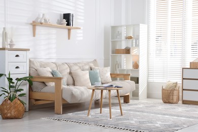 Beautiful sofa with cushions and coffee table in living room. Interior design