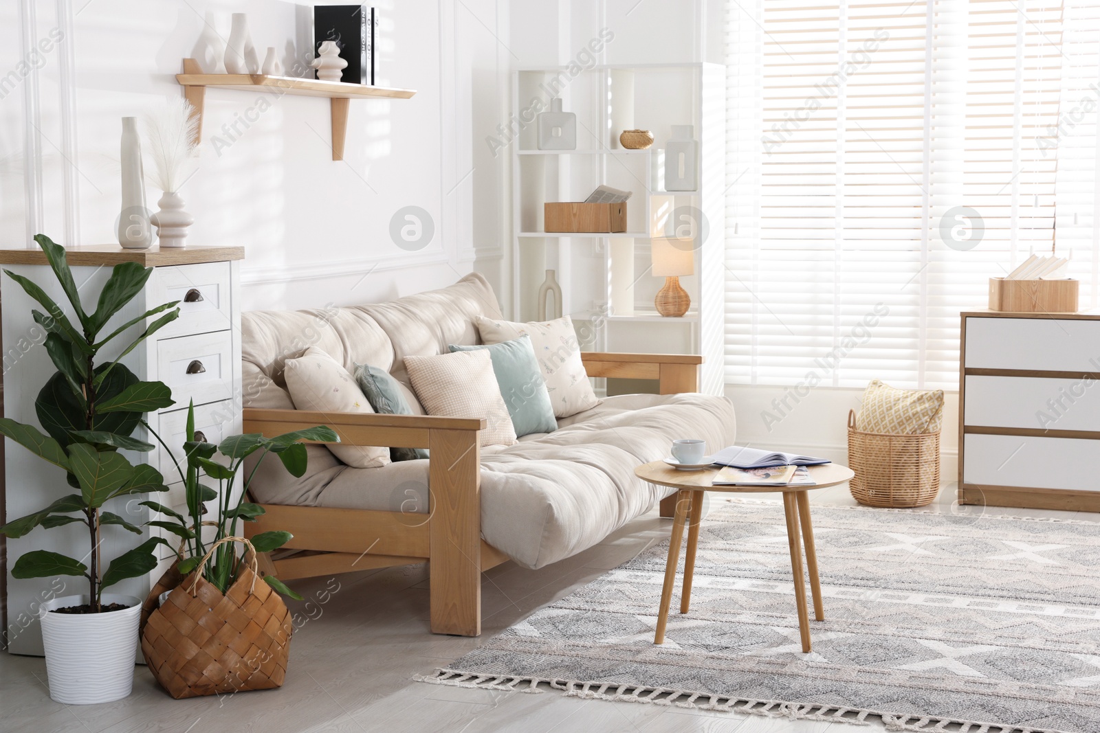 Photo of Beautiful sofa with cushions and coffee table in living room. Interior design