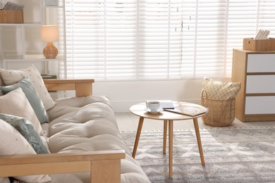 Beautiful sofa with cushions and coffee table in living room. Interior design