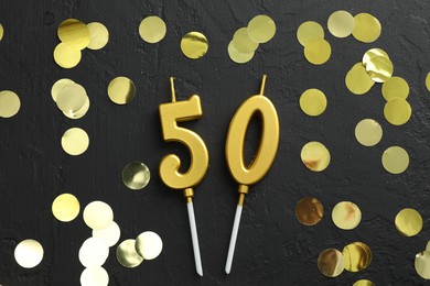 Photo of 50th birthday. Number shaped candles and confetti on black background, flat lay