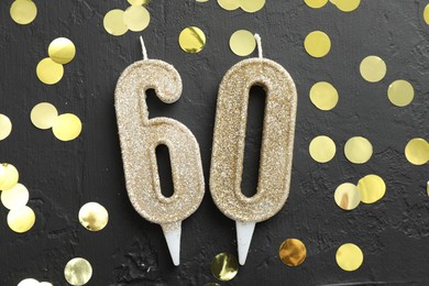 Photo of 60th birthday. Number shaped candles and confetti on black background, flat lay