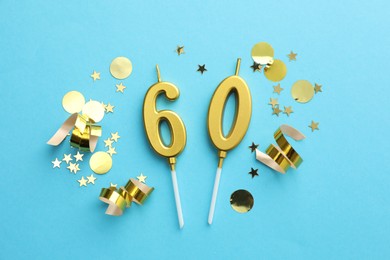 Photo of 60th birthday. Number shaped candles and confetti on light blue background, flat lay