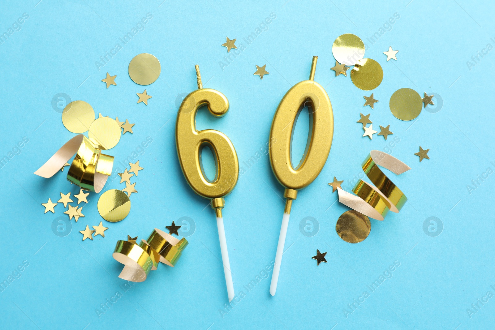 Photo of 60th birthday. Number shaped candles and confetti on light blue background, flat lay