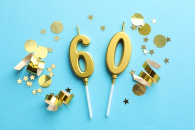 Photo of 60th birthday. Number shaped candles and confetti on light blue background, flat lay