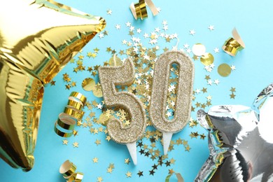 Photo of 50th birthday. Number shaped candles, balloons and confetti on light blue background, flat lay