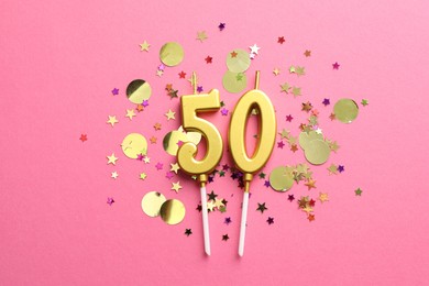 Photo of 50th birthday. Number shaped candles and confetti on pink background, flat lay