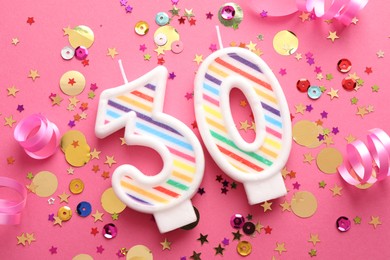 Photo of 30th birthday. Number shaped candles and confetti on pink background, flat lay