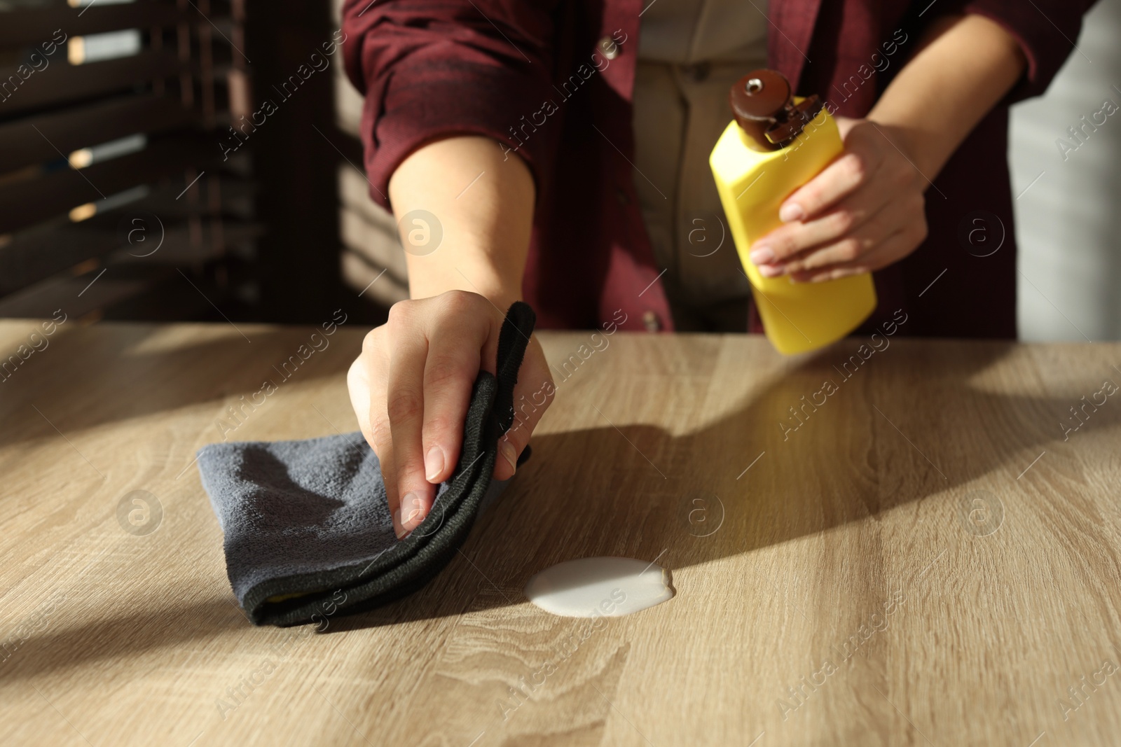 Photo of Woman polishing wooden table at home, closeup