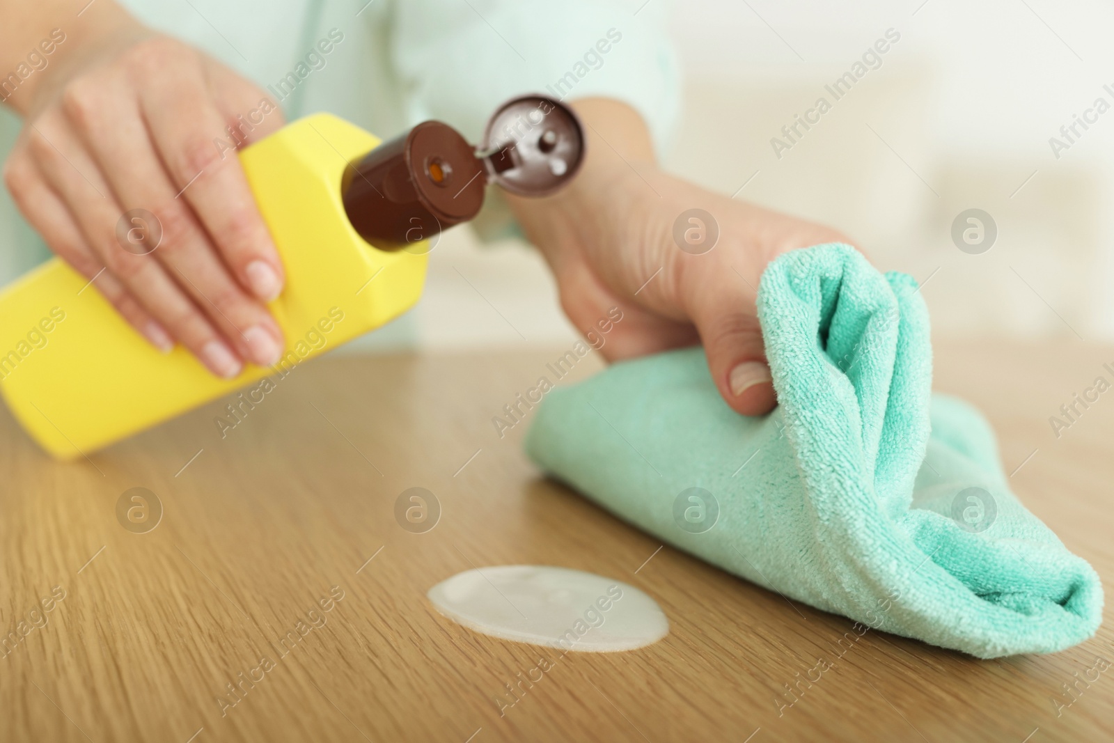 Photo of Woman polishing wooden table at home, closeup