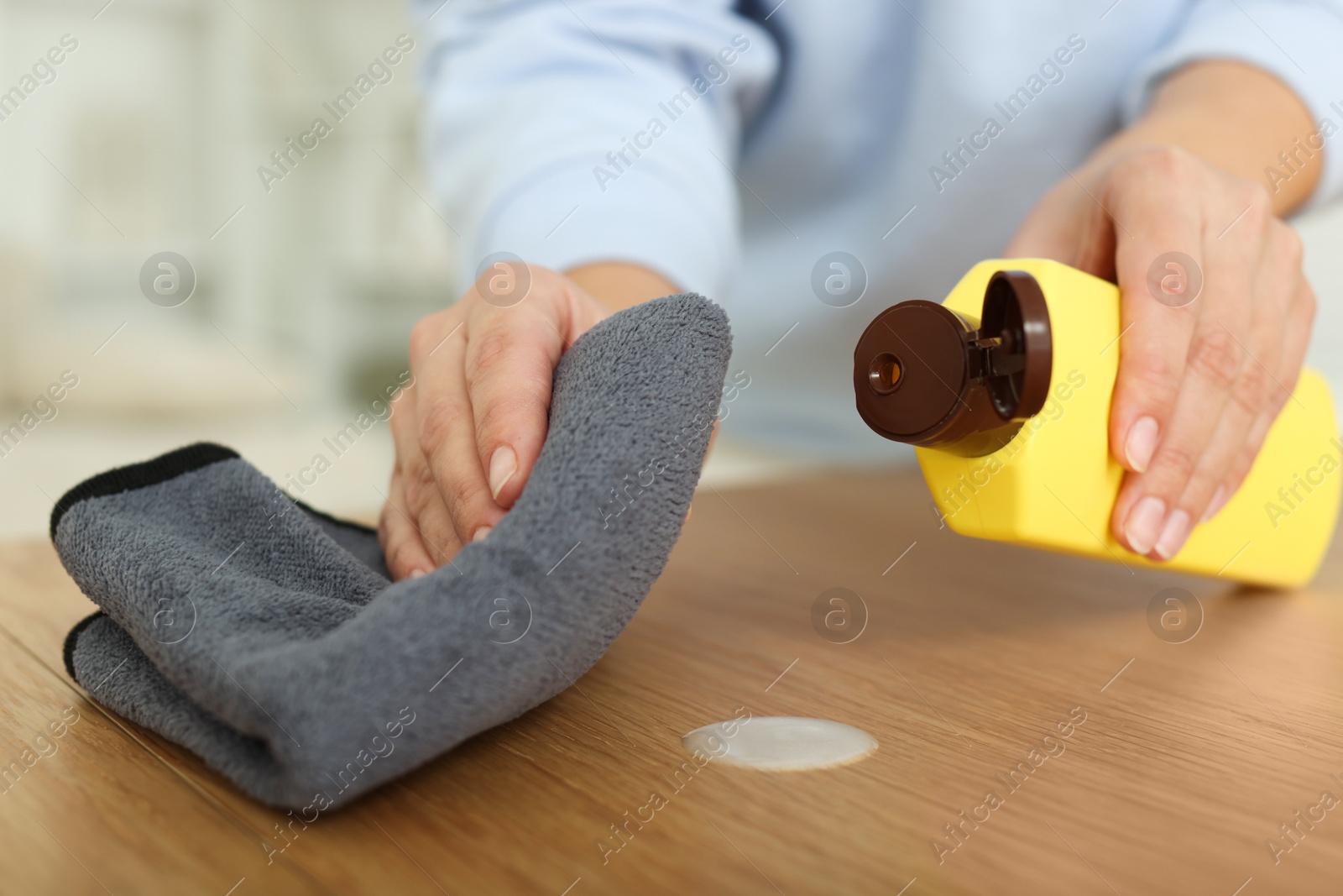 Photo of Woman polishing wooden table at home, closeup