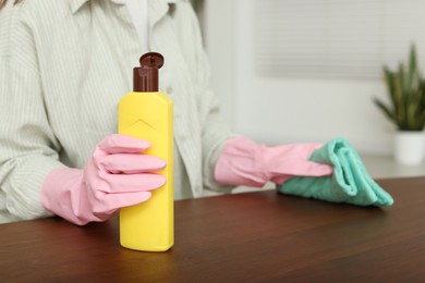 Photo of Woman polishing wooden table at home, closeup