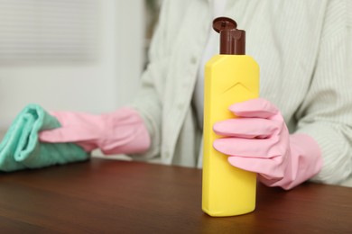 Photo of Woman polishing wooden table at home, closeup