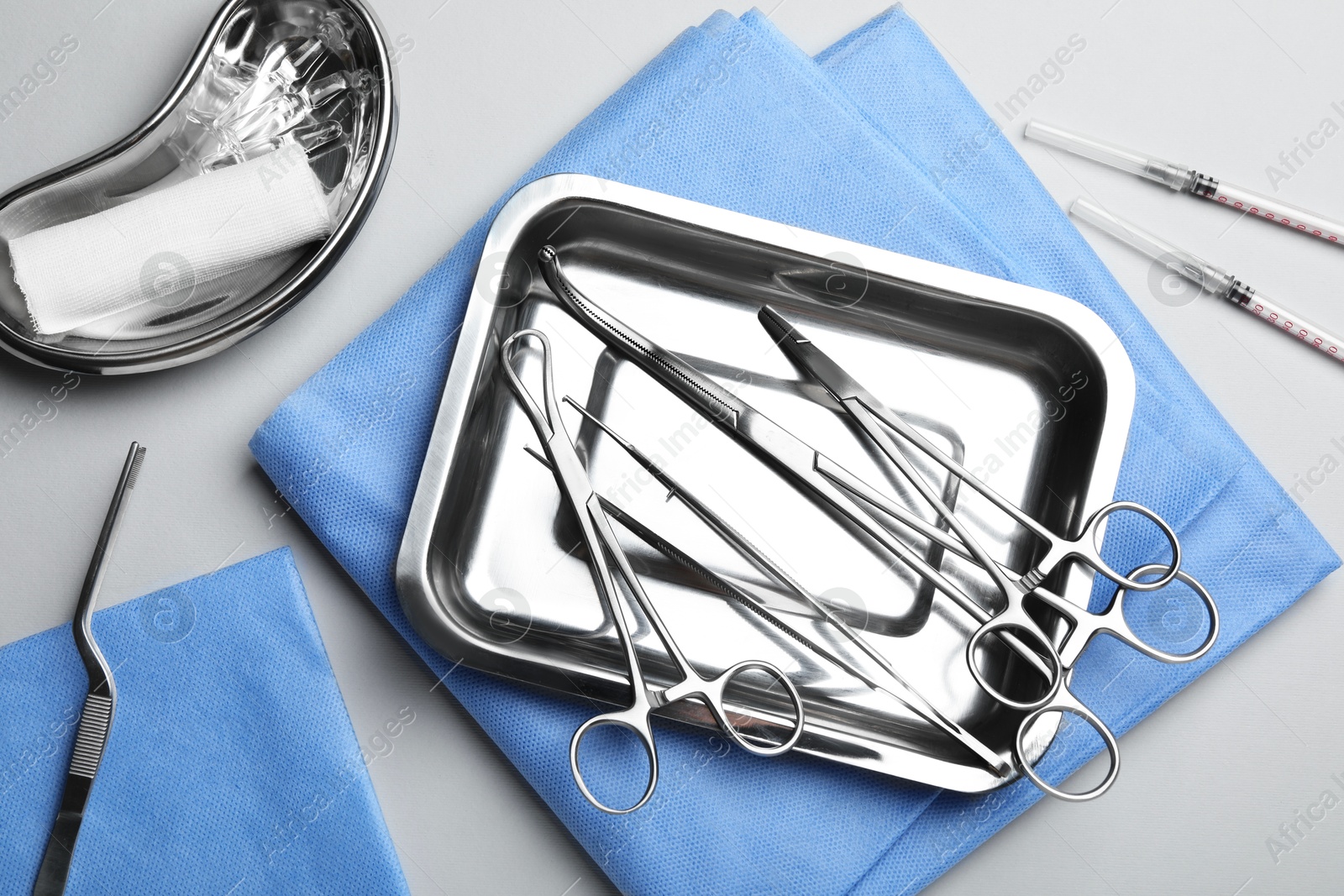 Photo of Different surgical tools on light gray background, flat lay