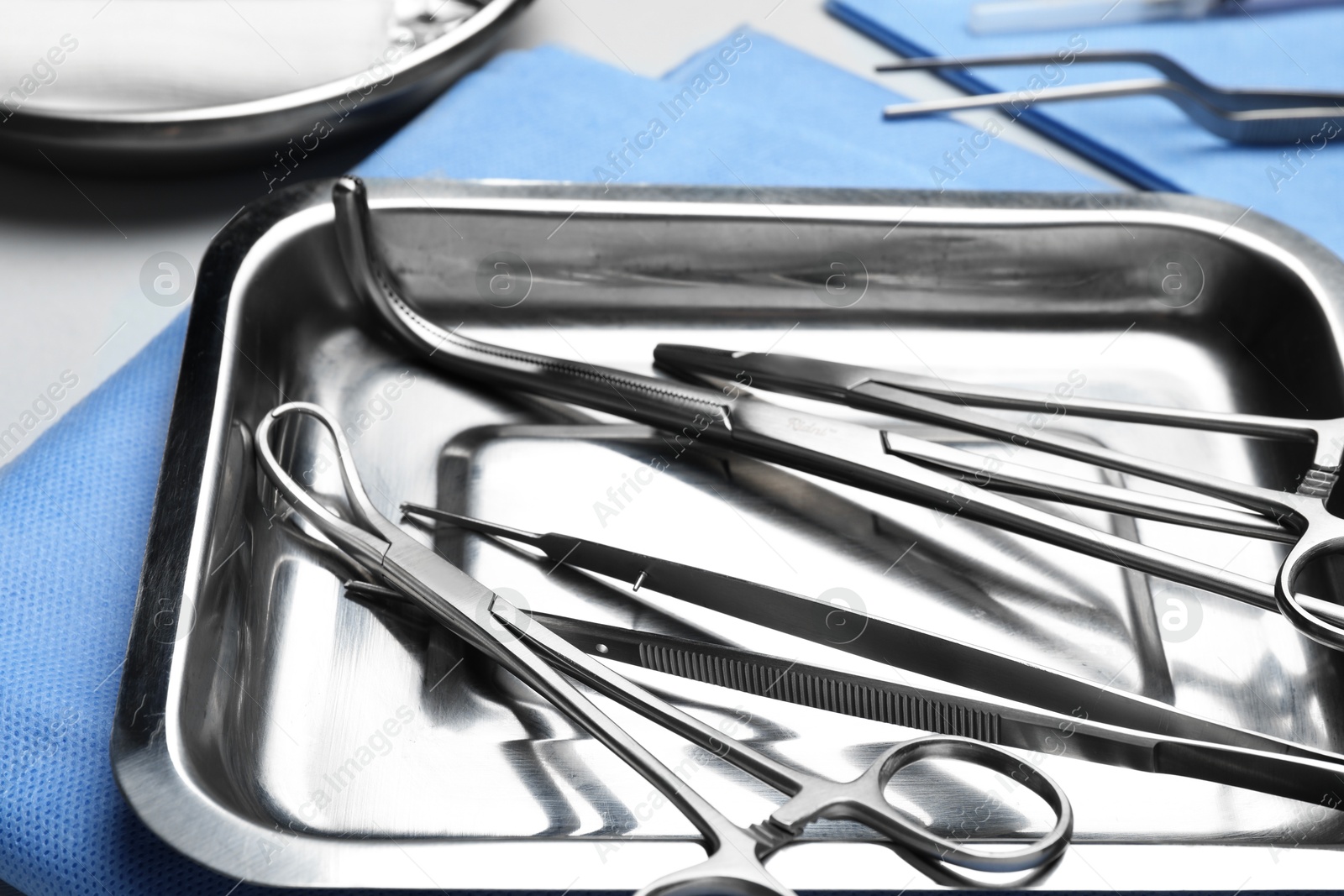 Photo of Different surgical tools on light gray background, closeup