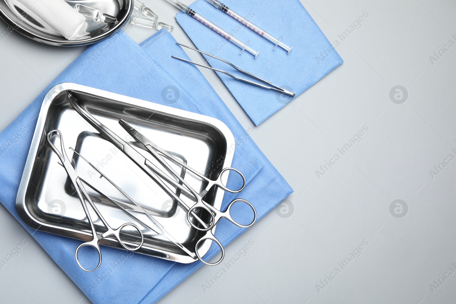 Photo of Different surgical tools on light gray background, flat lay. Space for text