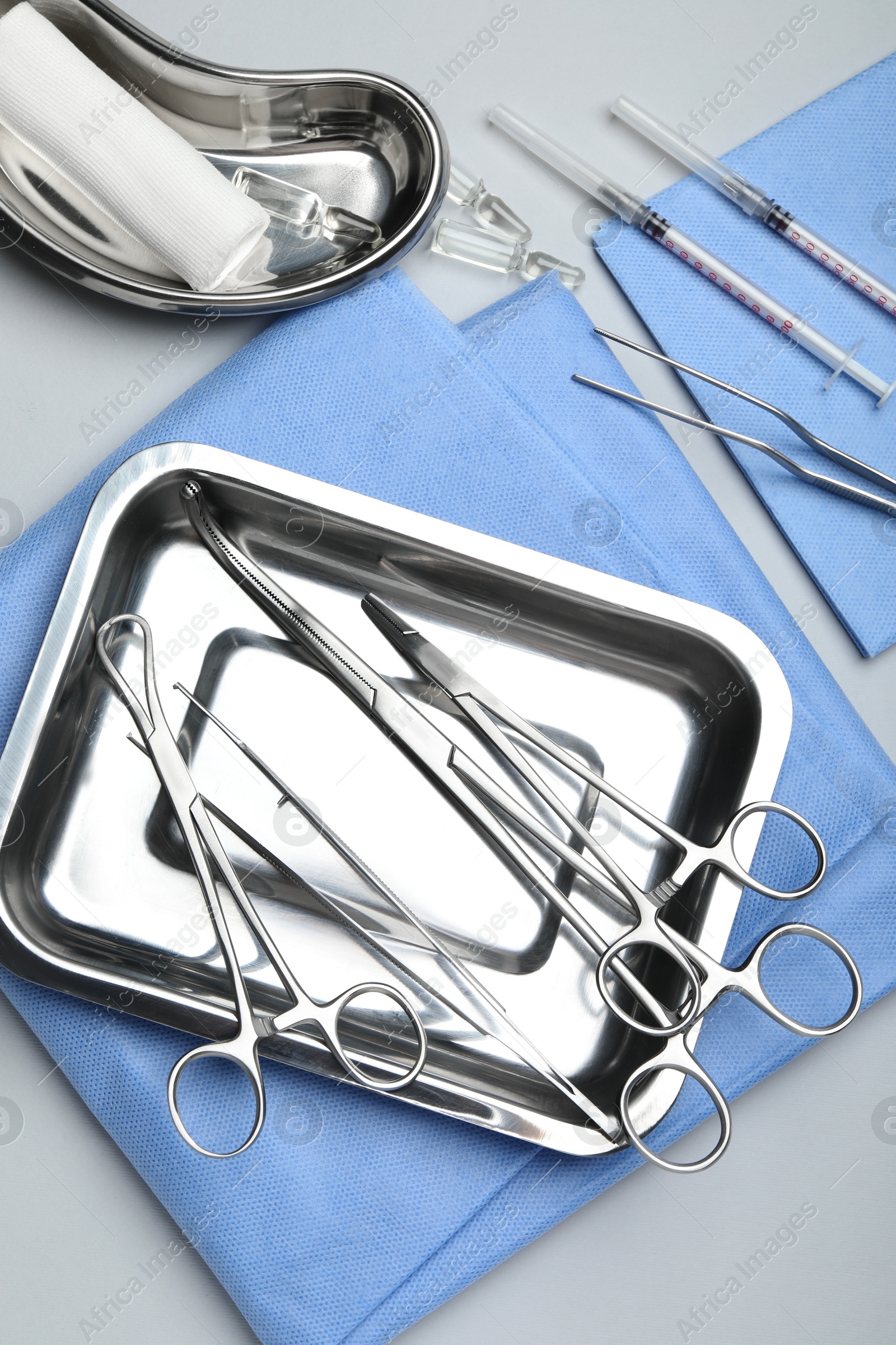 Photo of Different surgical tools on light gray background, flat lay