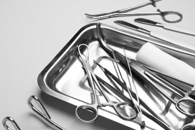 Different surgical tools on light gray background, closeup. Space for text