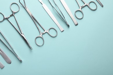 Different surgical tools on turquoise background, flat lay. Space for text