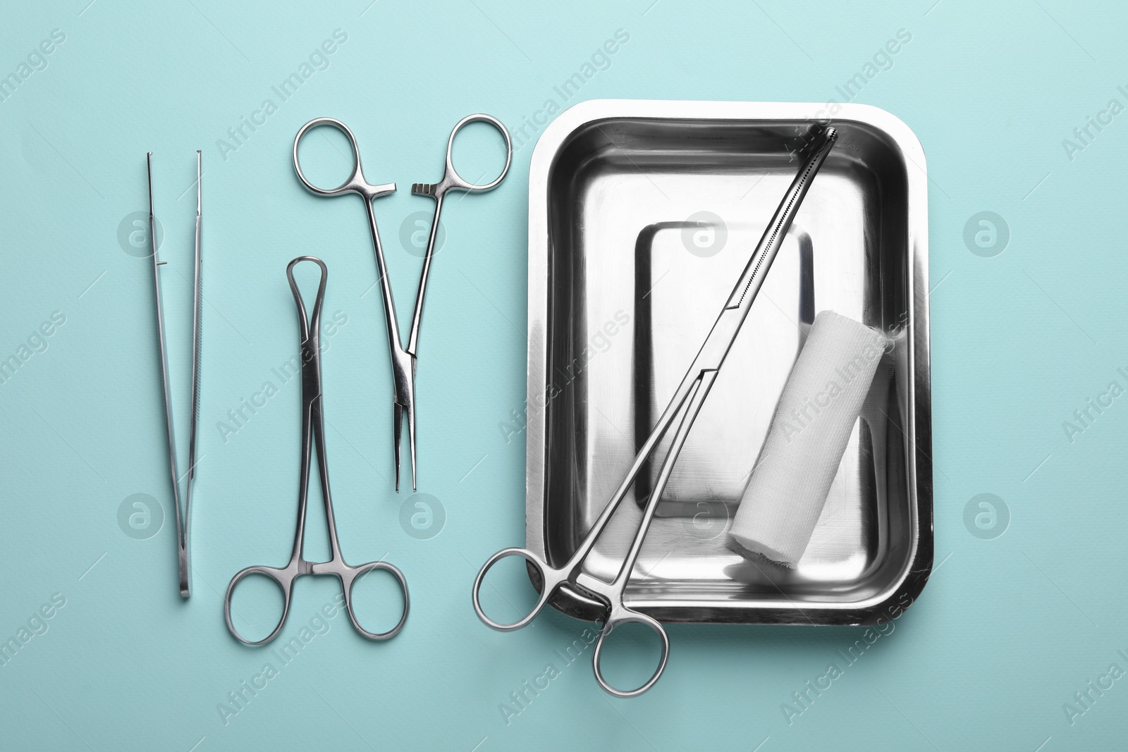 Photo of Different surgical tools on turquoise background, flat lay