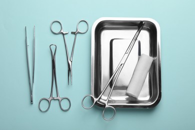 Different surgical tools on turquoise background, flat lay