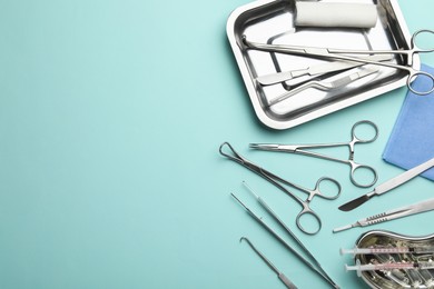 Different surgical tools on turquoise background, flat lay. Space for text