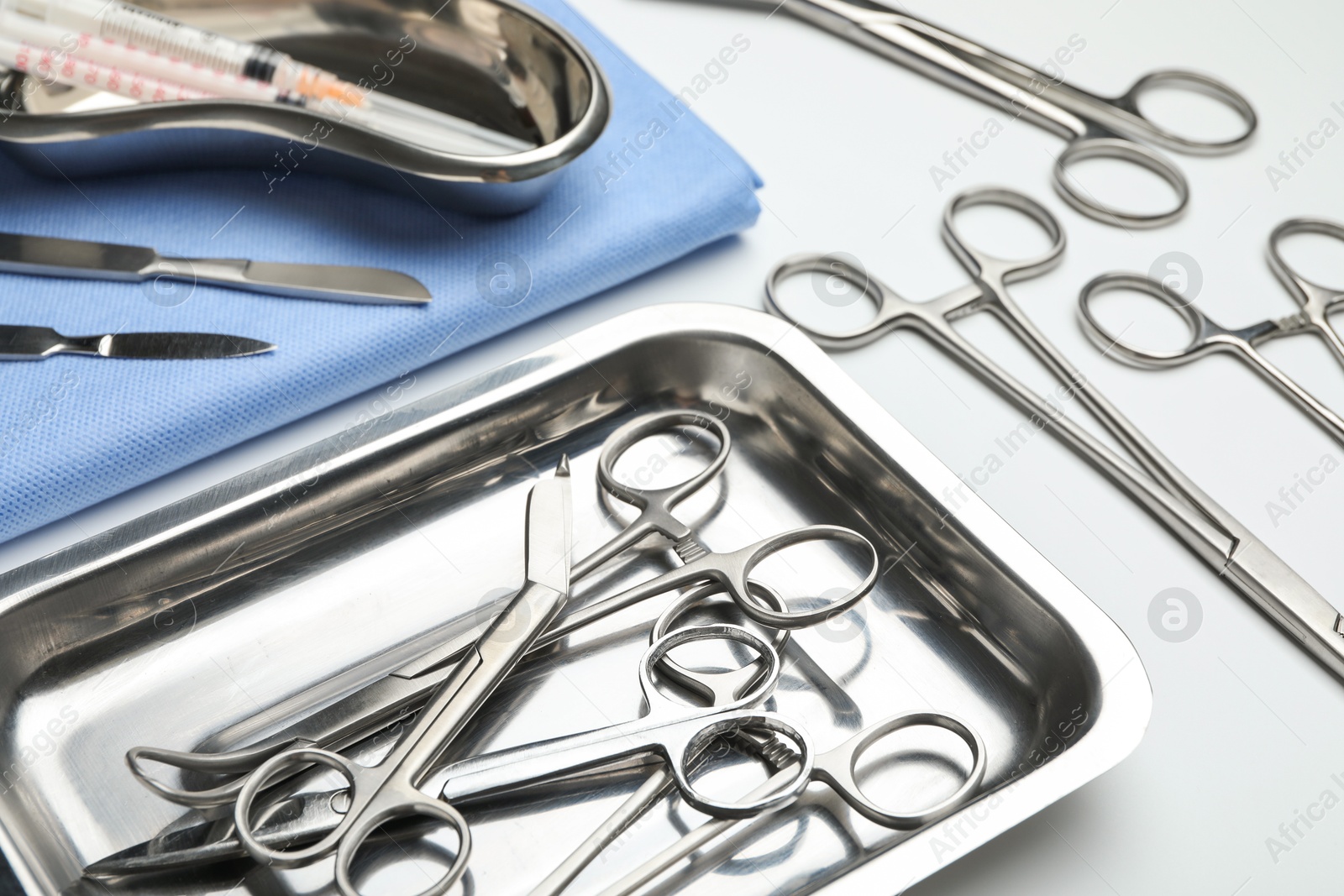 Photo of Different surgical tools on light gray background, closeup